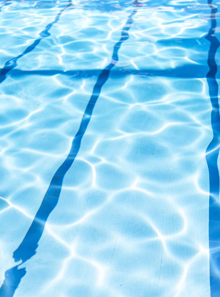 Ripple Water in swimming pool with sun reflection. Summer day at swimming pool.